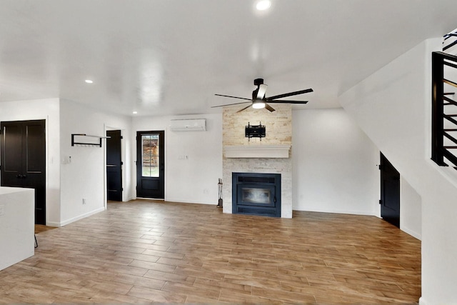 450 Juan Tomas Rd, Tijeras, NM 87059 - unfurnished living room with ceiling fan, a wall mounted AC, light wood-style flooring, a fireplace, and recessed lighting