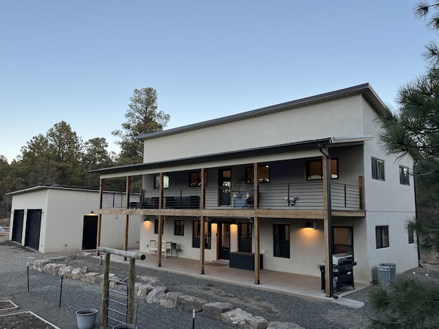 450 Juan Tomas Rd, Tijeras, NM 87059 - rear view of house featuring stucco siding, a balcony, a detached garage, and a patio area