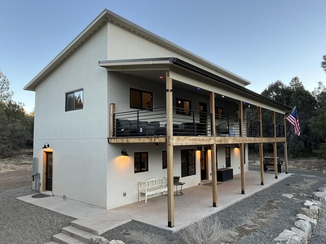 450 Juan Tomas Rd, Tijeras, NM 87059 - back of house featuring a balcony, a patio, and stucco siding