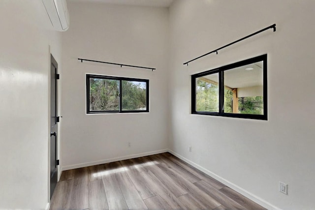 450 Juan Tomas Rd, Tijeras, NM 87059 - unfurnished room featuring wood finished floors and an AC wall unit
