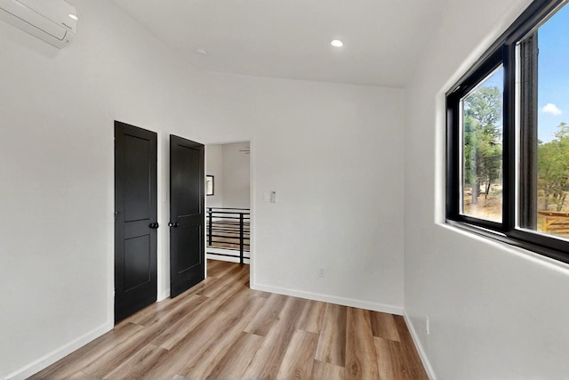 450 Juan Tomas Rd, Tijeras, NM 87059 - empty room featuring a wall mounted air conditioner, light wood-style flooring, and recessed lighting