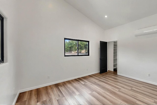 450 Juan Tomas Rd, Tijeras, NM 87059 - unfurnished bedroom with an AC wall unit, high vaulted ceiling, light wood-type flooring, and recessed lighting
