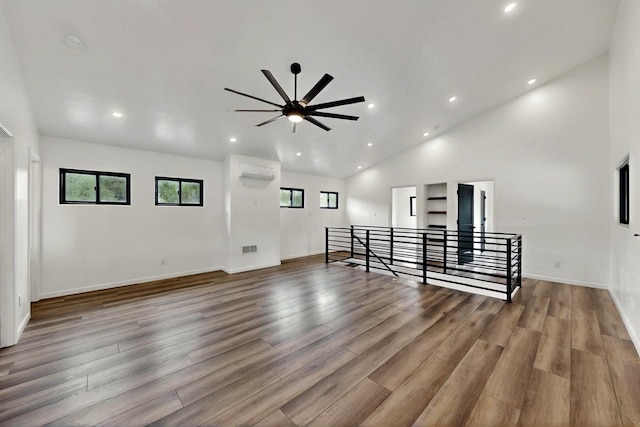 450 Juan Tomas Rd, Tijeras, NM 87059 - unfurnished living room with recessed lighting, wood finished floors, a ceiling fan, a wall mounted AC, and high vaulted ceiling