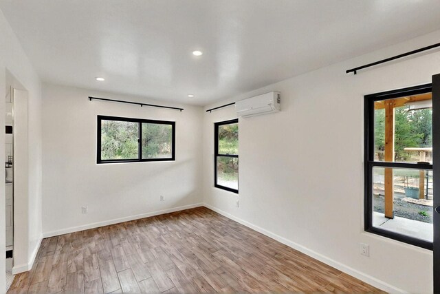 450 Juan Tomas Rd, Tijeras, NM 87059 - unfurnished room with a wall mounted AC, wood finished floors, and recessed lighting