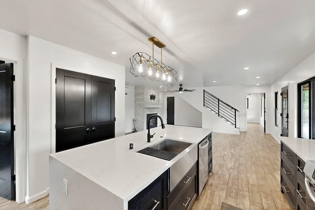 450 Juan Tomas Rd, Tijeras, NM 87059 - kitchen with open floor plan, a large fireplace, light wood-style floors, a kitchen island with sink, and ceiling fan