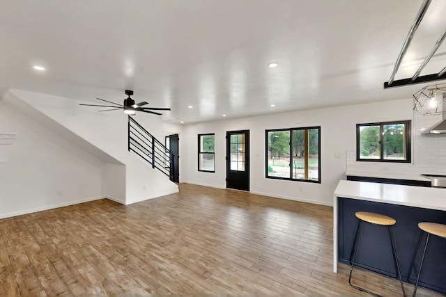 450 Juan Tomas Rd, Tijeras, NM 87059 - unfurnished living room with healthy amount of natural light, light wood finished floors, stairs, recessed lighting, and ceiling fan