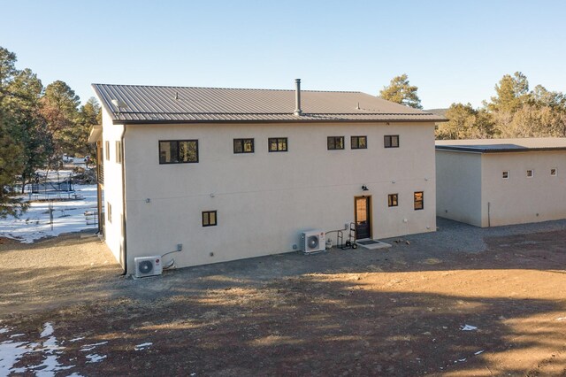 rear view of property with ac unit and metal roof