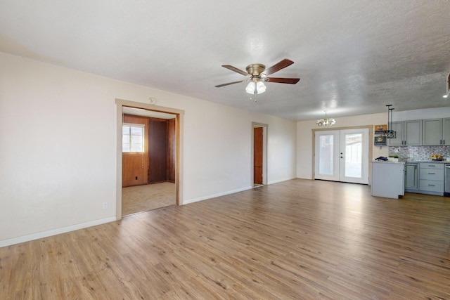 unfurnished living room with ceiling fan, a textured ceiling, light hardwood / wood-style floors, and french doors