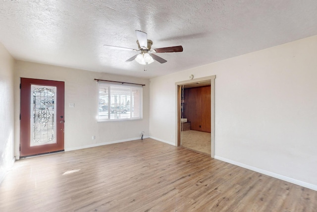 interior space featuring ceiling fan, a textured ceiling, and light hardwood / wood-style floors