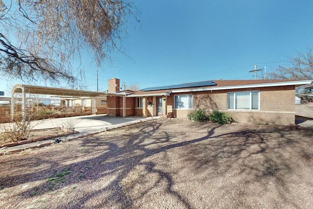 rear view of house featuring solar panels