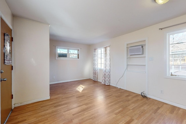 unfurnished room with light hardwood / wood-style floors and a wall mounted AC