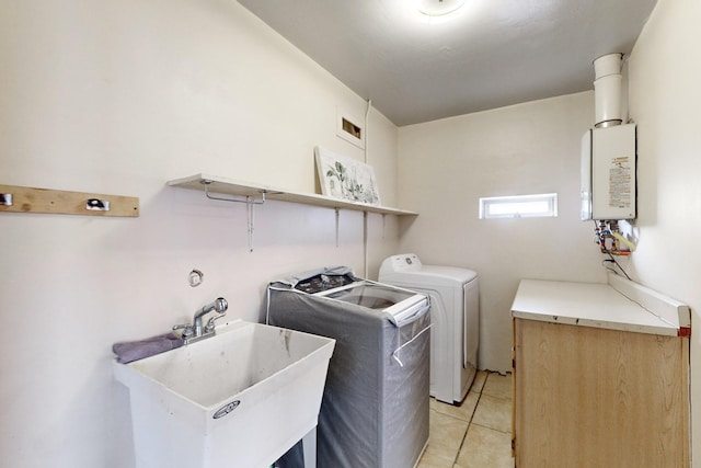 washroom featuring sink, light tile patterned floors, and washer and clothes dryer