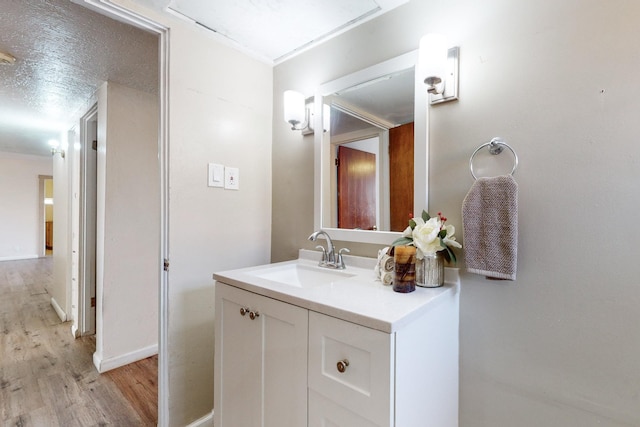 bathroom featuring hardwood / wood-style flooring, vanity, and a textured ceiling