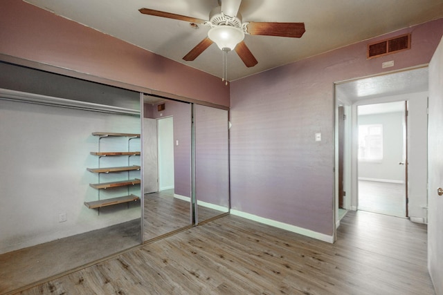 unfurnished bedroom with ceiling fan, light hardwood / wood-style floors, and a closet