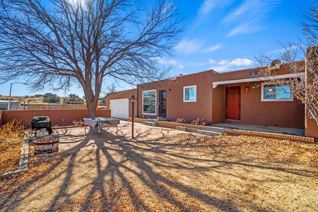 exterior space with an outdoor fire pit and a garage