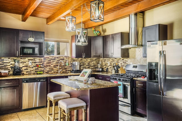 kitchen with appliances with stainless steel finishes, a kitchen breakfast bar, a center island, light stone counters, and wall chimney exhaust hood