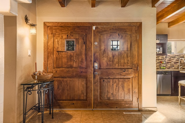 tiled entrance foyer with beamed ceiling