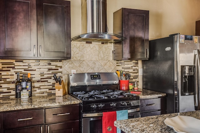 kitchen featuring stone counters, decorative backsplash, wall chimney exhaust hood, and appliances with stainless steel finishes