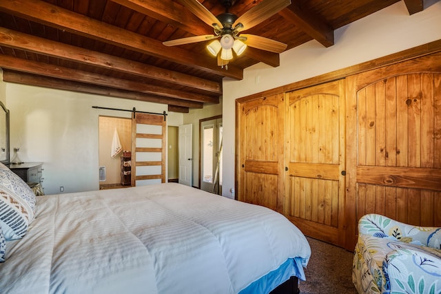 carpeted bedroom with a closet, wood ceiling, a barn door, and beamed ceiling