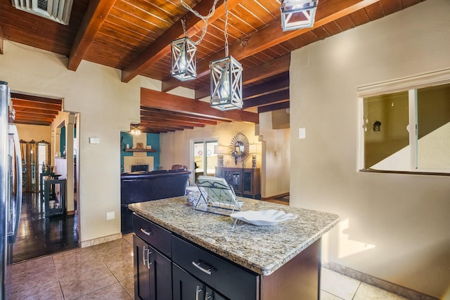 kitchen with light tile patterned flooring, wood ceiling, decorative light fixtures, a center island, and beam ceiling