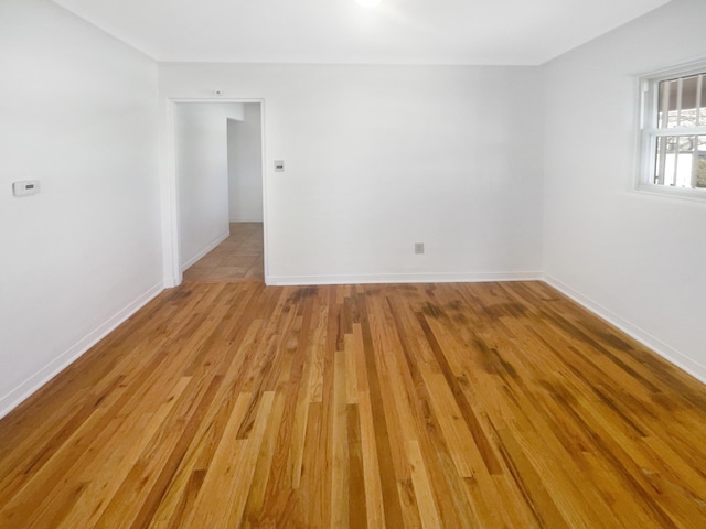 empty room with light wood-style flooring and baseboards