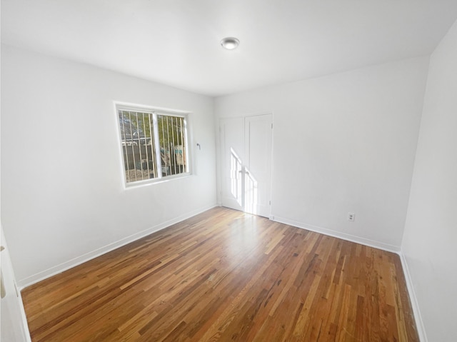 unfurnished room featuring baseboards and wood finished floors