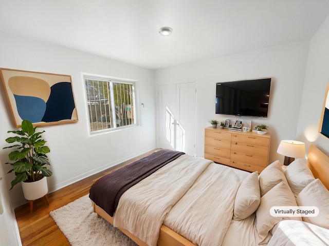 bedroom featuring baseboards and wood finished floors