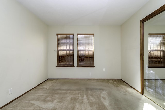 spare room featuring a wealth of natural light and light colored carpet