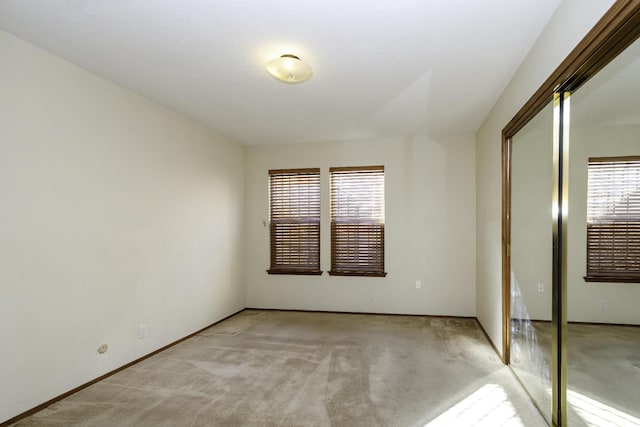 unfurnished bedroom featuring light colored carpet and a closet