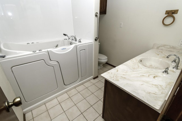 bathroom with vanity, a bath, tile patterned floors, and toilet