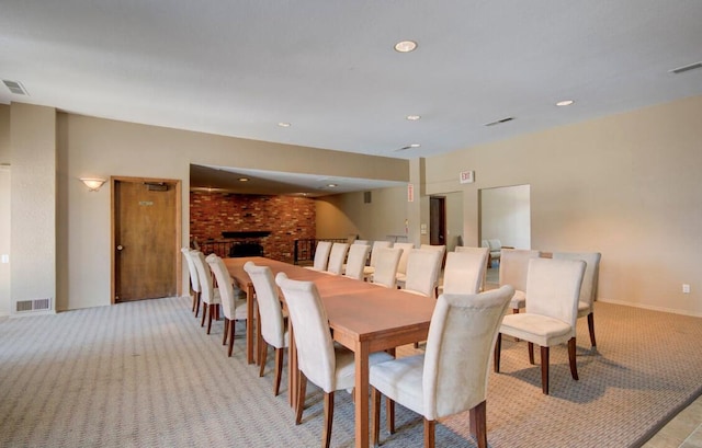 dining space featuring light colored carpet and a fireplace