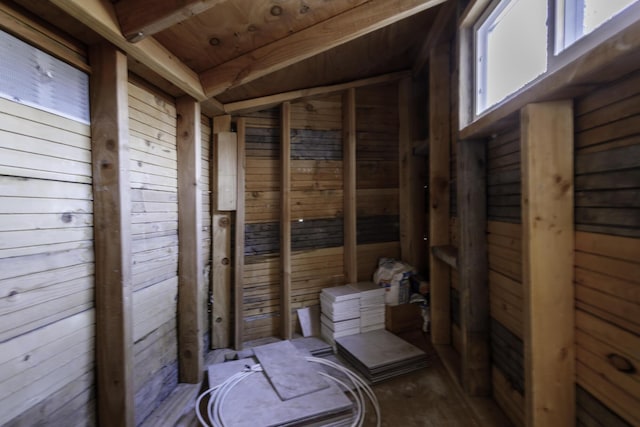 interior space with wood ceiling, wooden walls, and vaulted ceiling