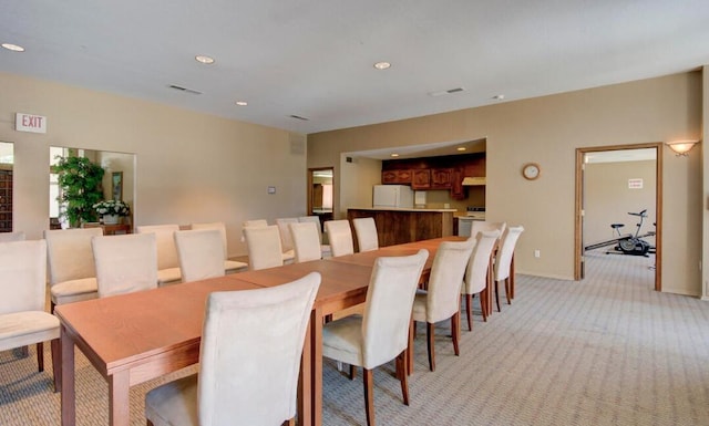 dining space featuring light carpet