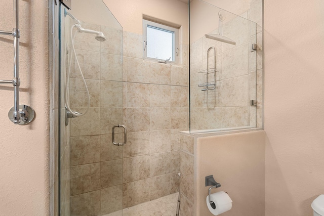 bathroom with toilet and a shower with shower door