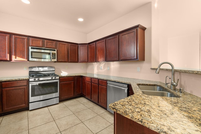 kitchen featuring light stone counters, appliances with stainless steel finishes, sink, and light tile patterned floors