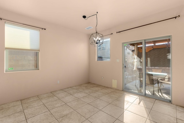 unfurnished dining area with a notable chandelier and light tile patterned floors