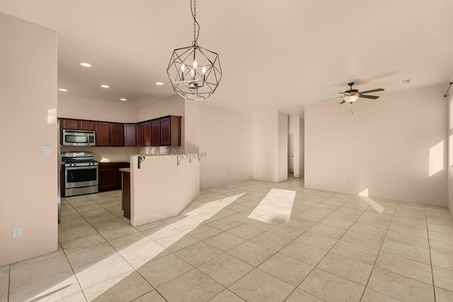 kitchen featuring appliances with stainless steel finishes, ceiling fan with notable chandelier, hanging light fixtures, and light tile patterned floors