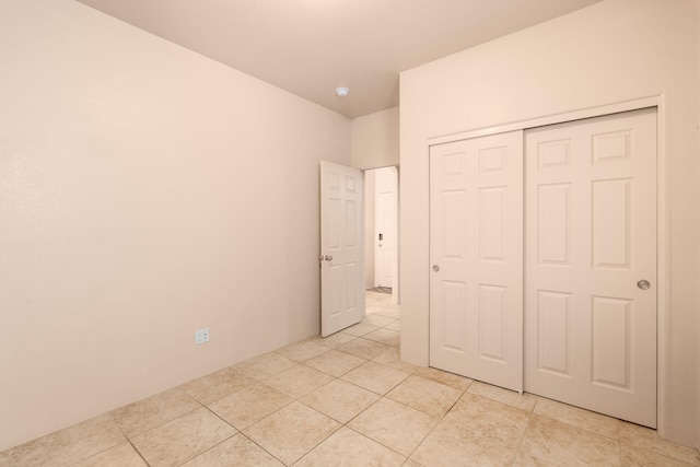 unfurnished bedroom with a closet and light tile patterned floors