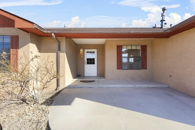 view of exterior entry with a patio area