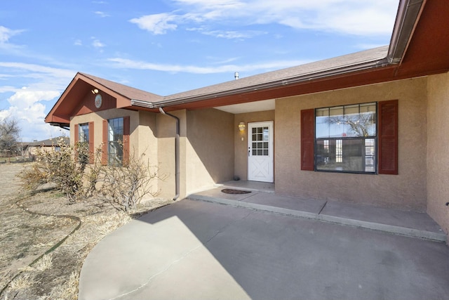 1 Blackberry Ln, Los Lunas, NM 87031 - view of exterior entry with stucco siding and a patio