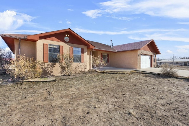 ranch-style house featuring stucco siding, an attached garage, and concrete driveway