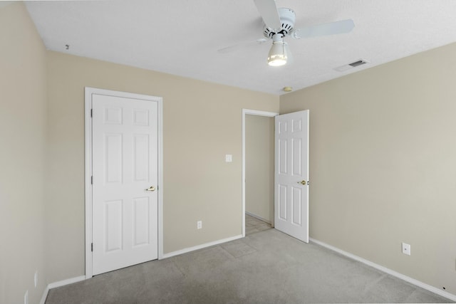 unfurnished bedroom with light colored carpet and ceiling fan