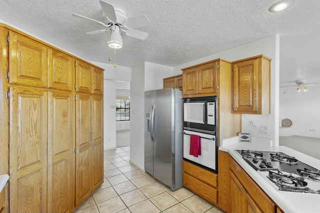 kitchen featuring ceiling fan, white appliances, a textured ceiling, and light tile patterned floors