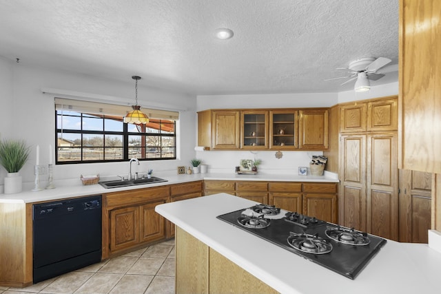 kitchen with sink, hanging light fixtures, light tile patterned floors, ceiling fan, and black appliances