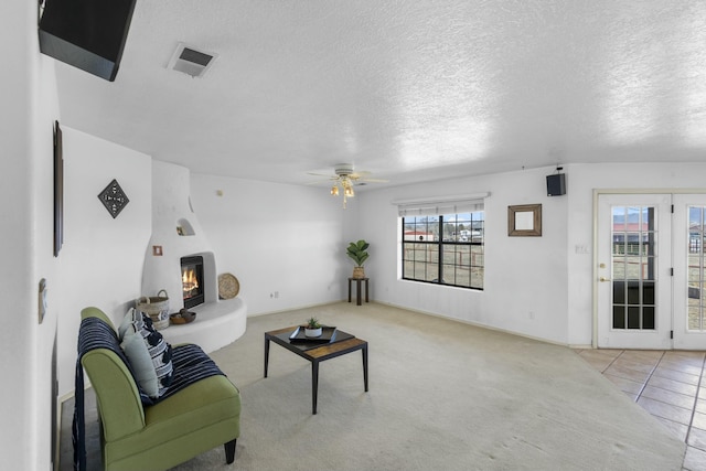 1 Blackberry Ln, Los Lunas, NM 87031 - living room featuring a large fireplace, a textured ceiling, visible vents, and ceiling fan