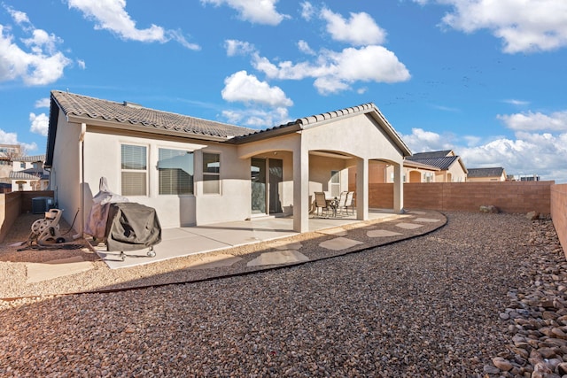 back of property with central AC unit and a patio area