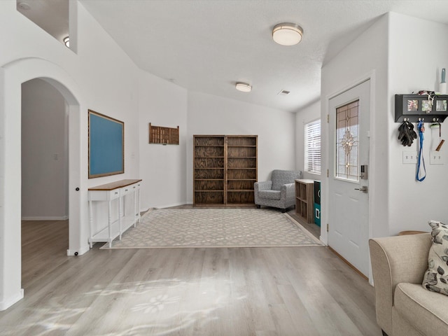 foyer entrance with lofted ceiling and light hardwood / wood-style flooring