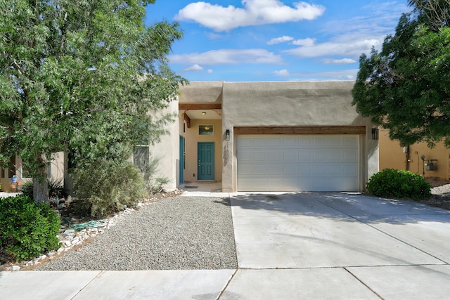 pueblo revival-style home featuring a garage