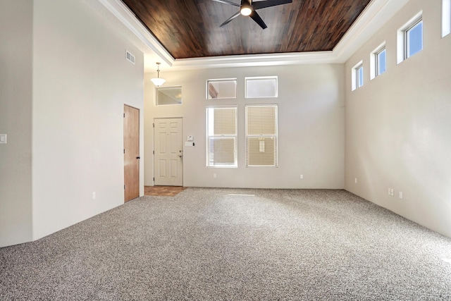 spare room with wood ceiling, a towering ceiling, ceiling fan, and carpet