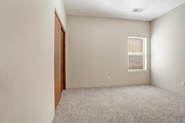 carpeted spare room featuring a textured ceiling